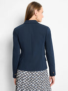Dark navy blue blazer, double-breasted, long sleeves with buttons.  Back view.