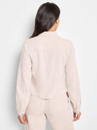 Beige linen jacket, long sleeves, button cuffs,  collared.  Shown from the back.