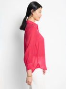 Crimson red, collared, long-sleeve shirt with slightly puffed sleeves and a curved hemline.