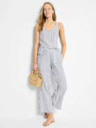 White tank top with thin, dark blue pinstripes; V-neck and frayed edges.