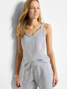 White tank top with thin, dark blue pinstripes. V-neck, frayed edges. Sleeveless.