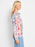 Off-white long-sleeved collared shirt with an abstract print in pinks, oranges, blues, and purples.