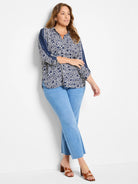 White shirt with navy blue geometric pattern and vertical stripes on sleeves.  Three-quarter sleeves.