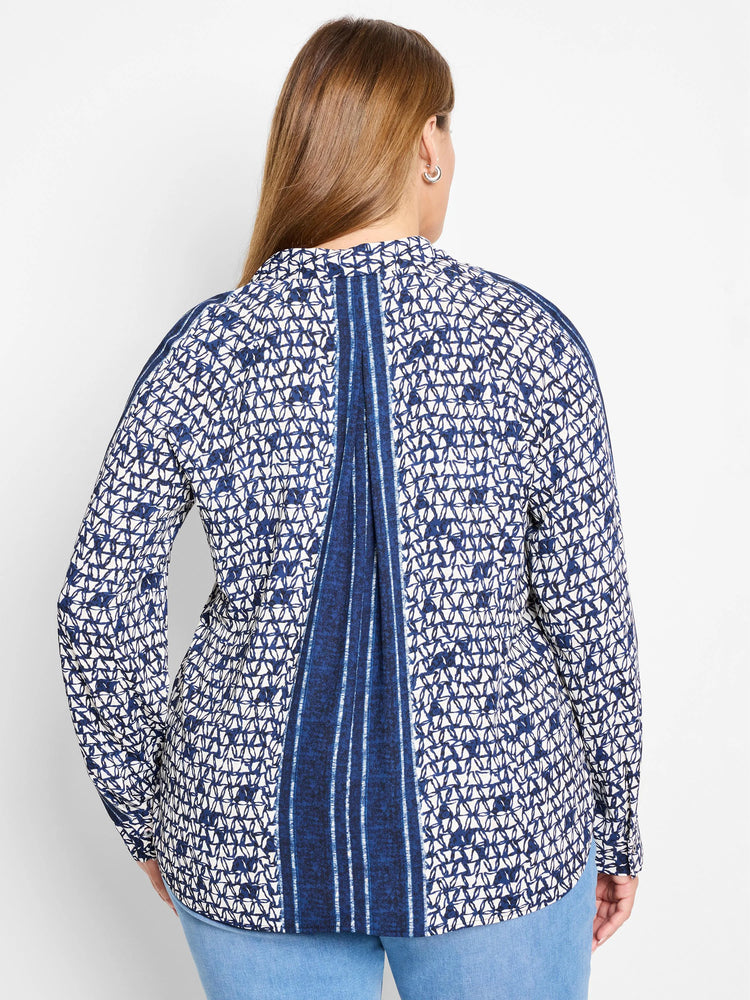 White shirt with navy blue geometric pattern and vertical stripes down the back. Long sleeves.