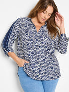 White shirt with navy blue geometric pattern; darker blue vertical stripes on sleeves.  Three-quarter sleeves, button front.