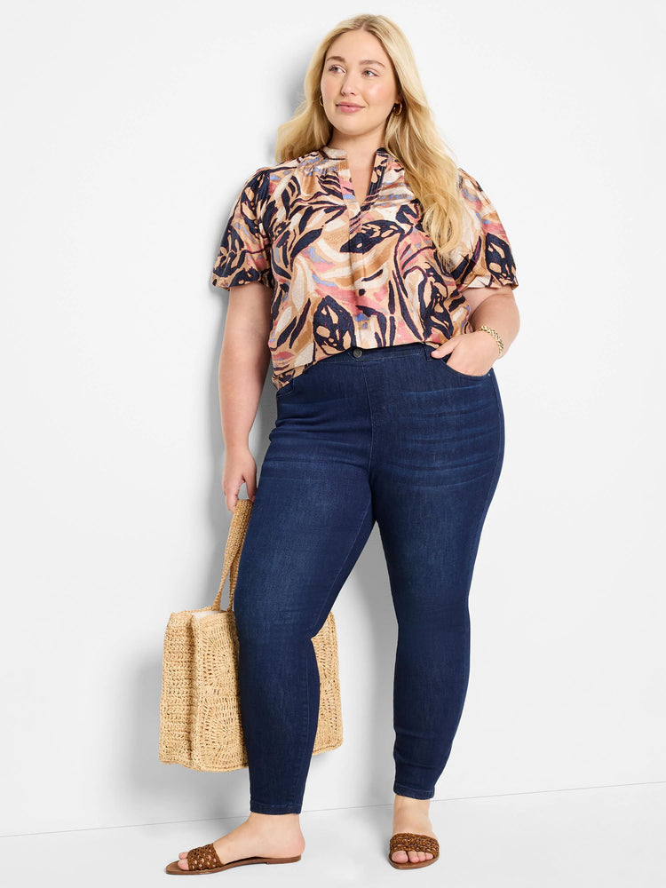 Dark wash denim leggings; model wears a tan, pink, and dark-blue abstract print top.