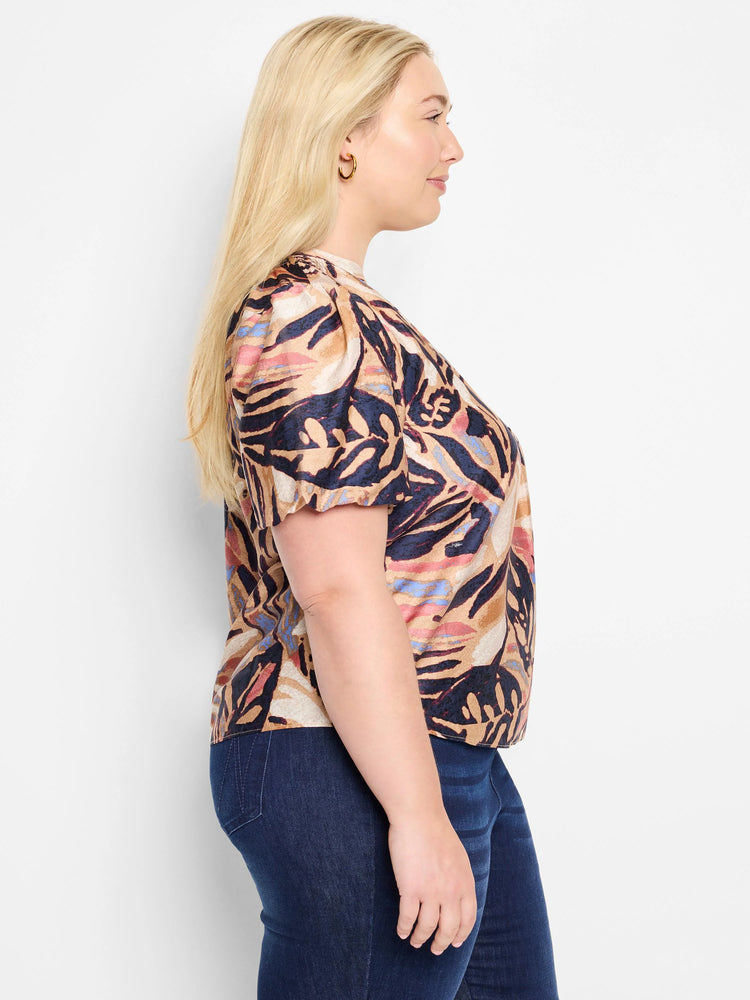 Terracotta top with short puff sleeves.  Abstract leaf print in beige, dark blue, and muted pink.