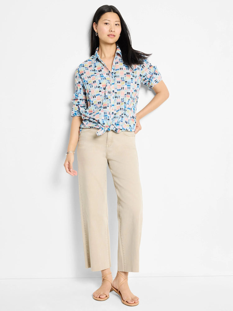 White cotton shirt with short sleeves and a blue, pink, and orange abstract print.  Shirt is knotted at the waist.