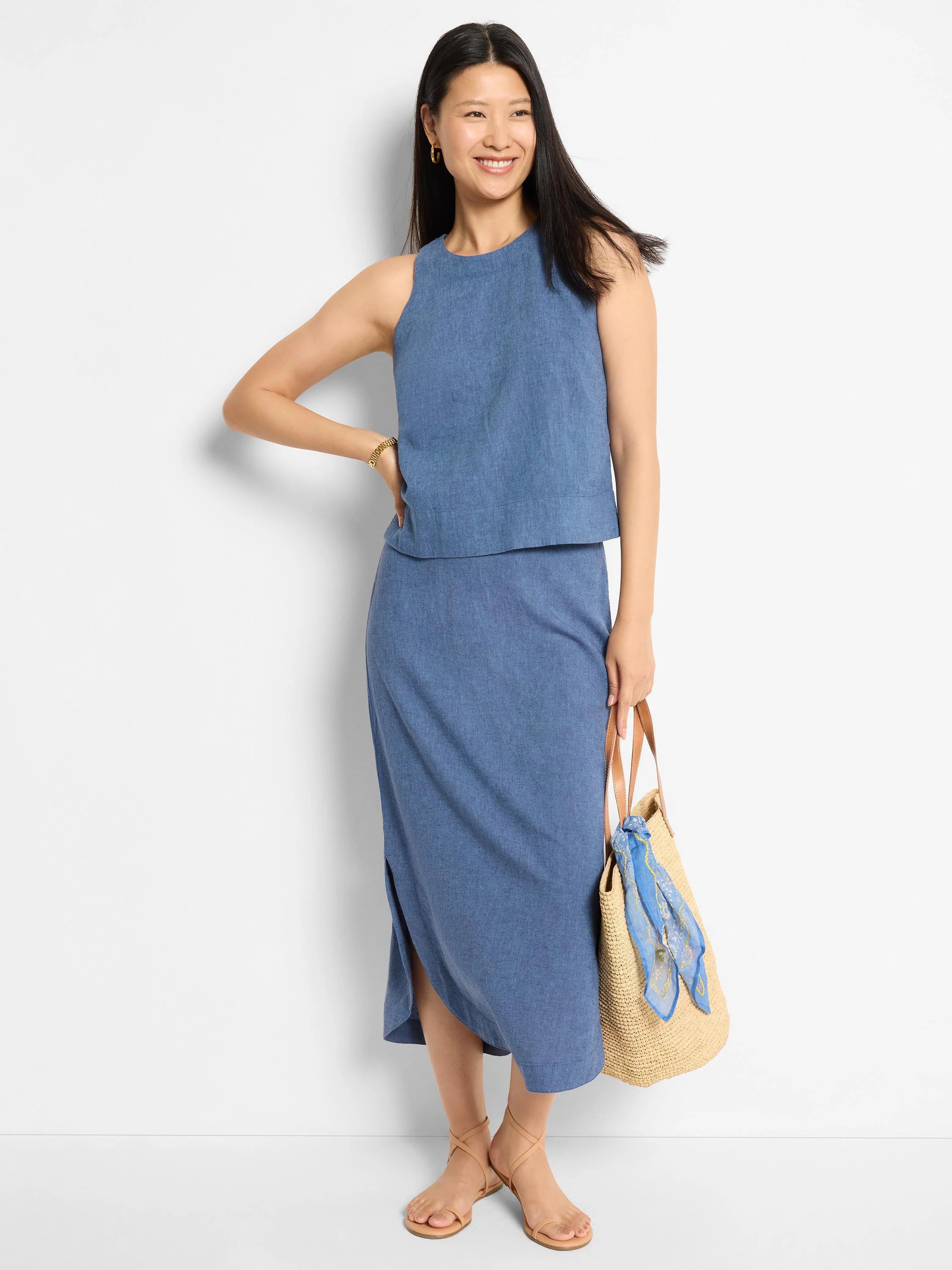 Blue linen midi skirt with a side slit.  Model is wearing it with a matching top and sandals.