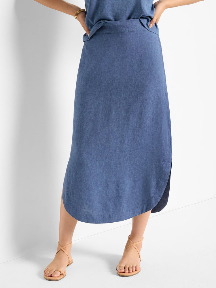 Mid-length denim blue linen skirt; asymmetrical hemline, curved.