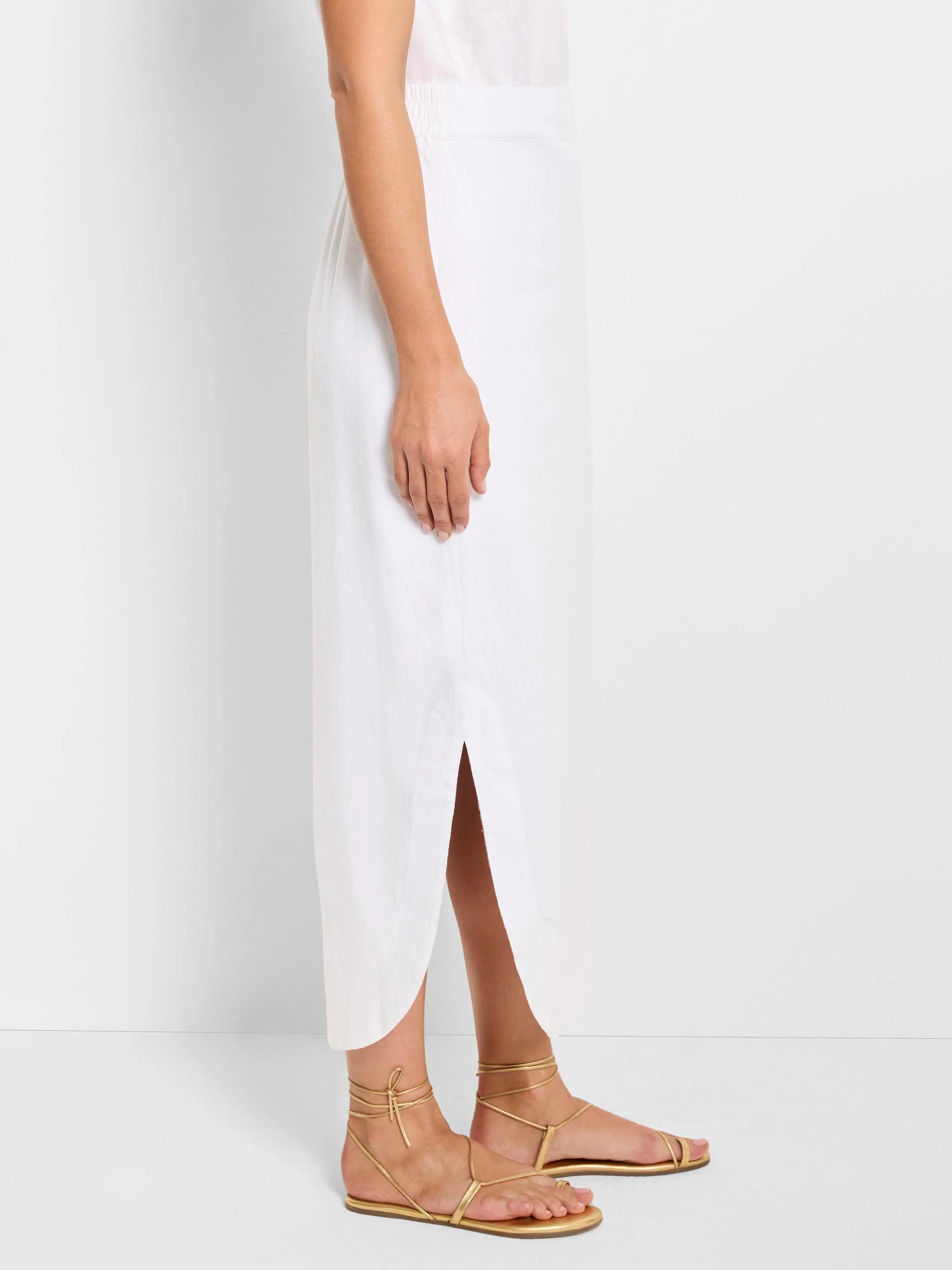 White linen midi skirt with a side slit and elastic waistband.