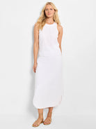 Off-white linen midi skirt with a curved hemline.  Model wears a similar-colored top and gold sandals.