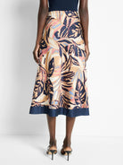 Terracotta midi skirt with abstract leaf print in beige, pink, blue, and navy.  Navy waistband.