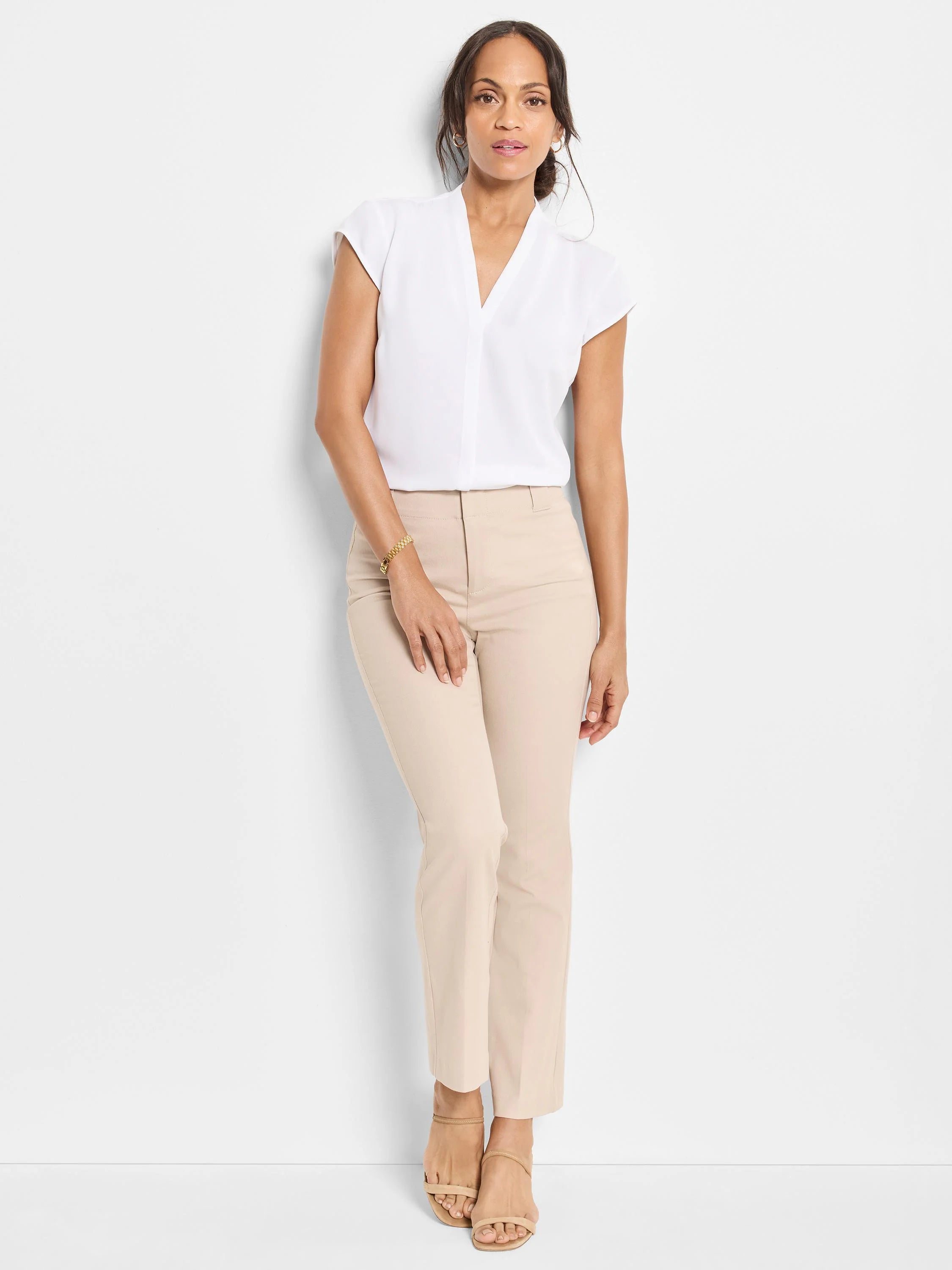 Light beige slim-fit pants with a flat front and straight leg, worn by a model.