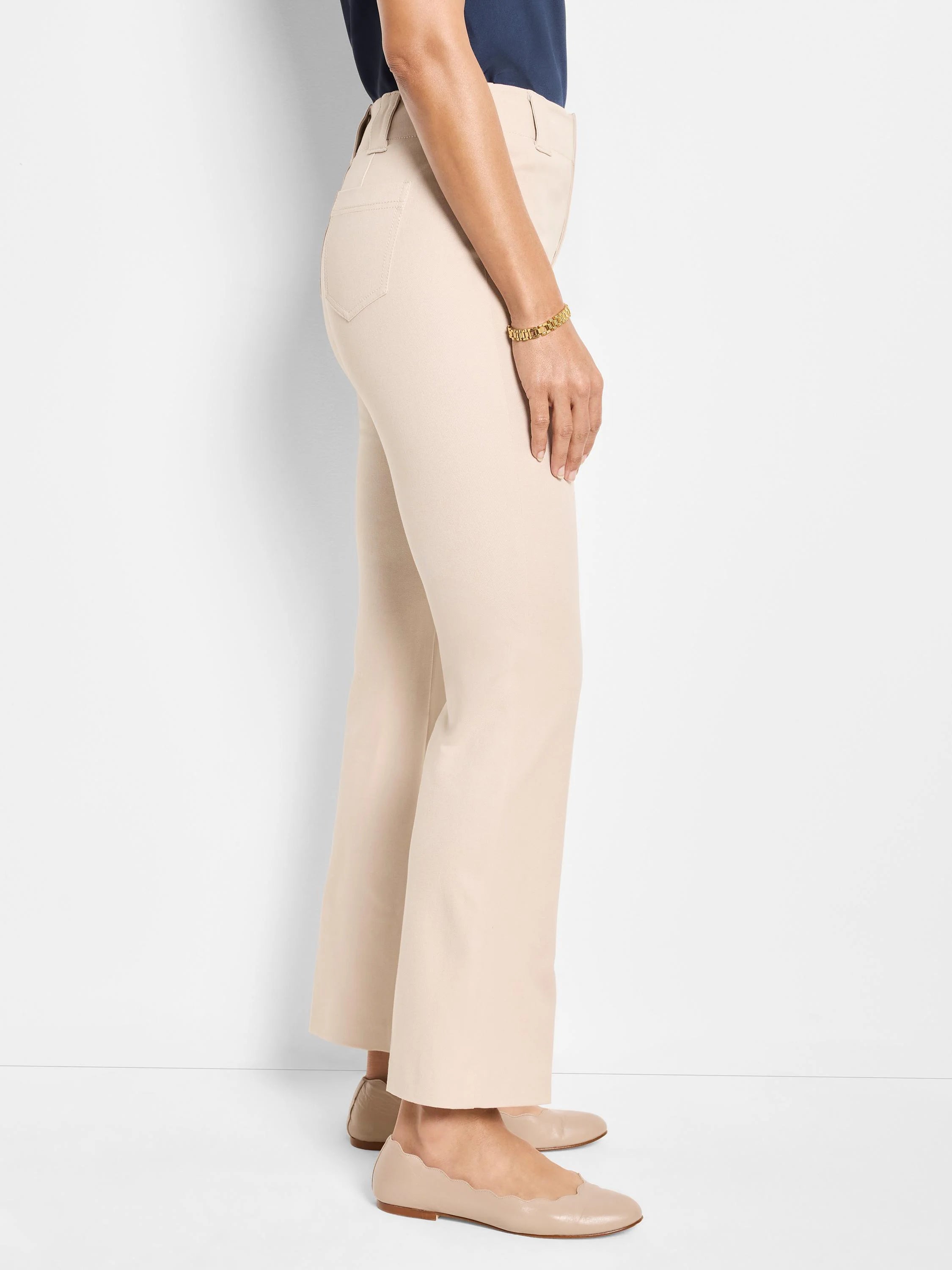 Light beige demi boot pants, side view. Features back pocket detail, gentle flare, and a cropped length.