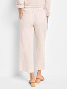 Beige linen pants with a drawstring waist and pockets.  Back view.