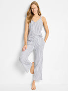 White wide-leg pants with thin, dark blue pinstripes and raw edges.  Model is wearing them with a matching top.