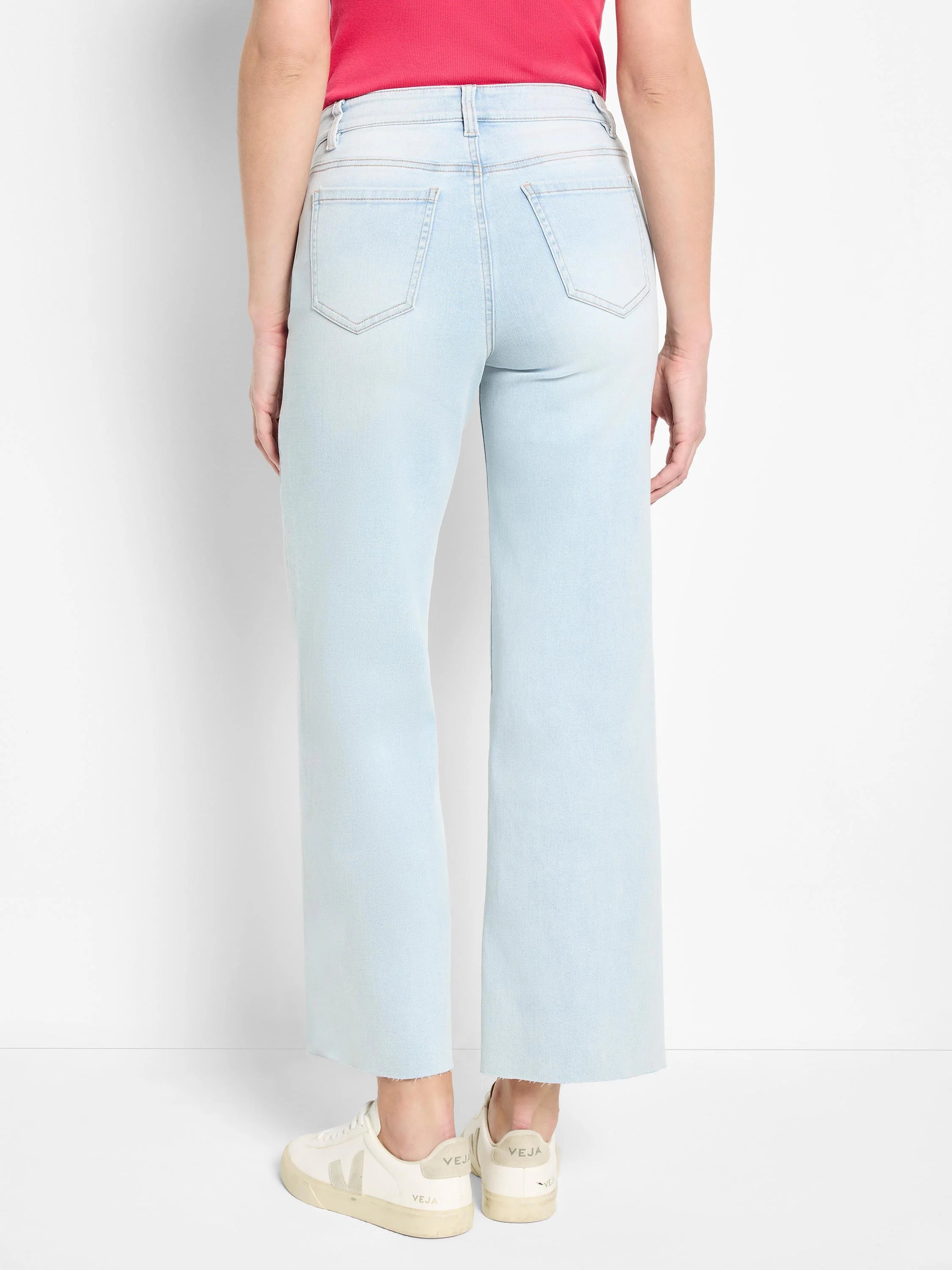 Light blue wide leg jeans shown from behind. Features a high waist, two back pockets, and a raw hem.