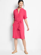 Pink linen dress with short sleeves, V-neck, pockets, and a self-tie belt with tassels.