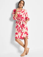 Pink dress with beige flower pattern, belted waist, button front, and elbow-length sleeves.