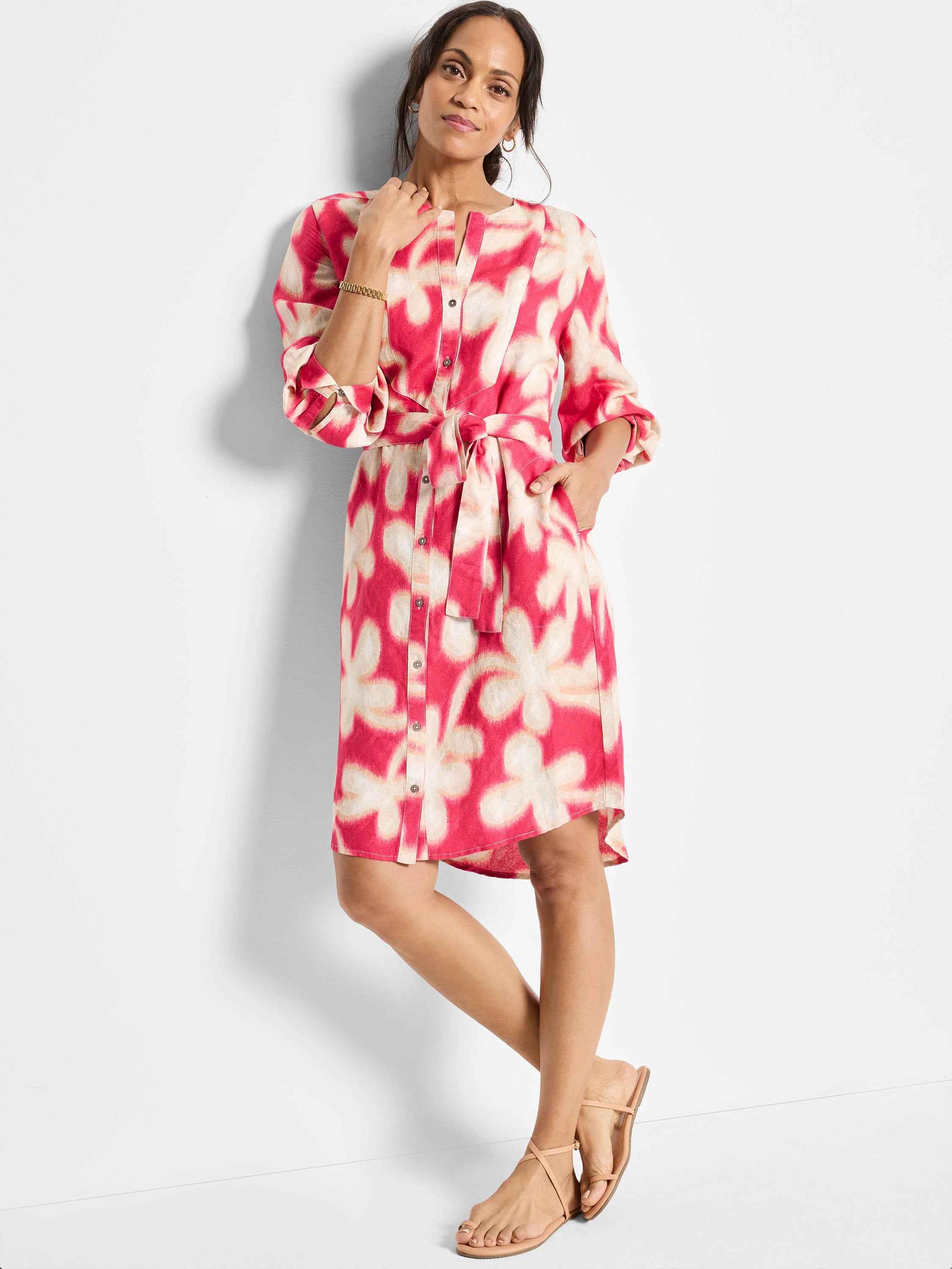Pink dress with beige flower pattern, belted waist, button front, and elbow-length sleeves.