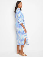White midi shirt dress with vertical blue, teal, and tan stripes.  Self-tie belt. Side slits.