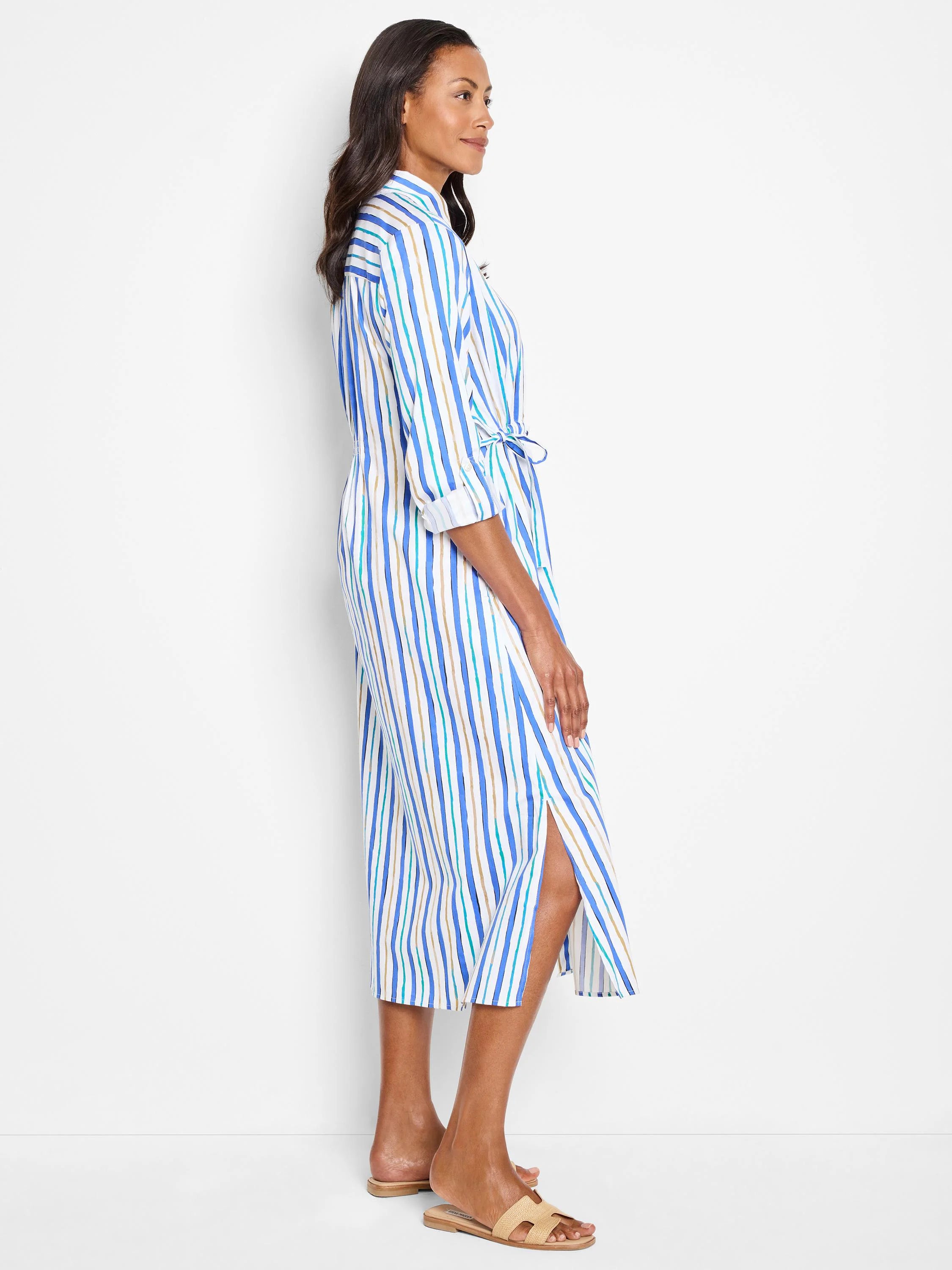 White midi shirt dress with vertical blue, teal, and tan stripes.  Self-tie belt. Side slits.
