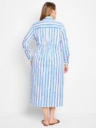 White midi dress with vertical blue, teal, and beige stripes.  Long sleeves, collared shirt neckline, and fitted waist.