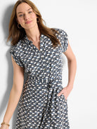 Short-sleeved collared dress with off-white background and a geometric pattern in navy and dark blue.  It has a belted waist.