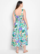Midi dress, sleeveless,  blue background with green, orange, & purple abstract leaf print.  Square neckline, back view.