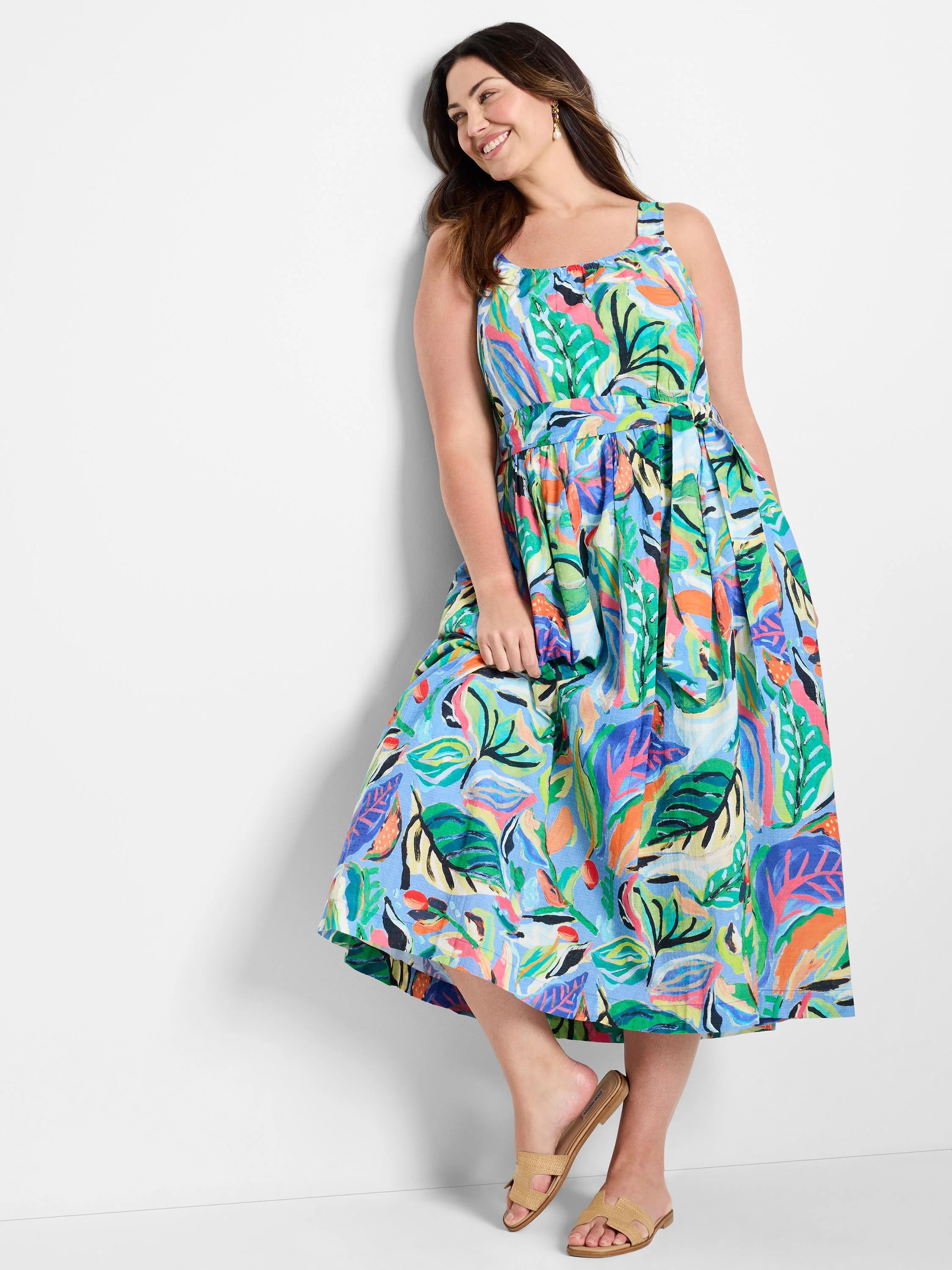 Mid-length sleeveless dress, light blue background with bright green, pink, orange, and dark blue tropical leaf print. ...