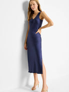 Navy blue bias-cut midi tank dress with a side slit.