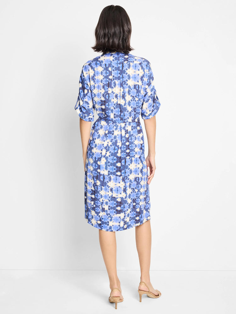 Back view of a belted knee-length dress with a blue, white, and dark-blue shibori print.  Short sleeves.