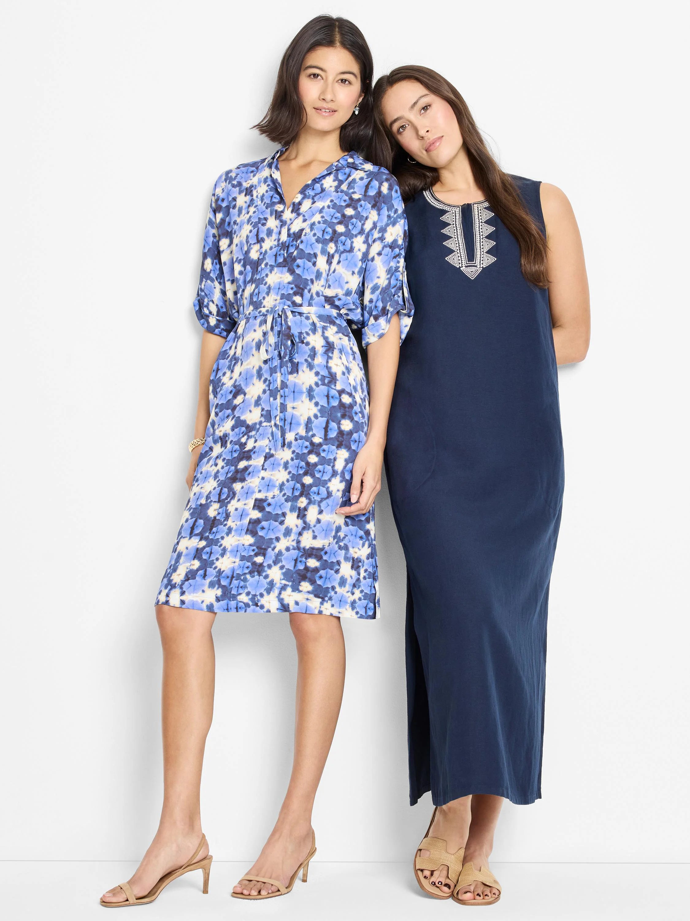 Shibori print knee-length dress in blues and creams; belted waist.  Shown next to a solid navy maxi dress with...