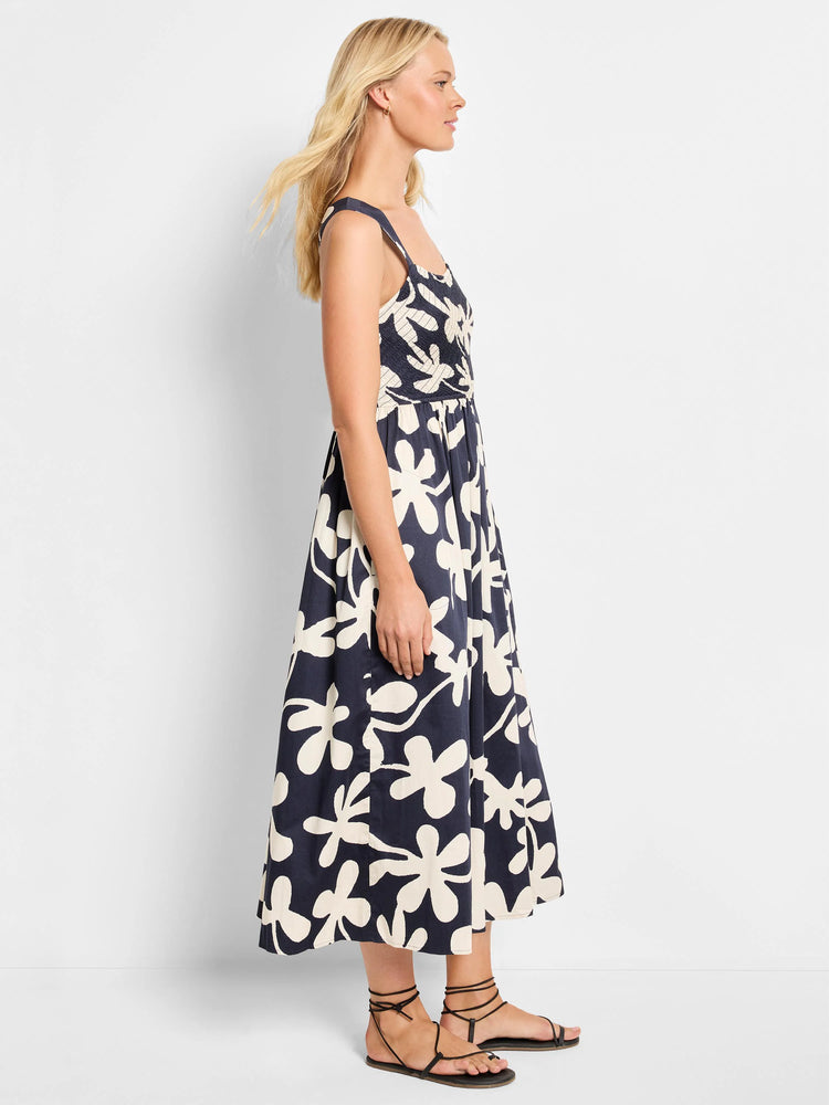 Midi-length sleeveless dress. Dark navy background with large off-white stylized floral print.  Square neckline, smocked...