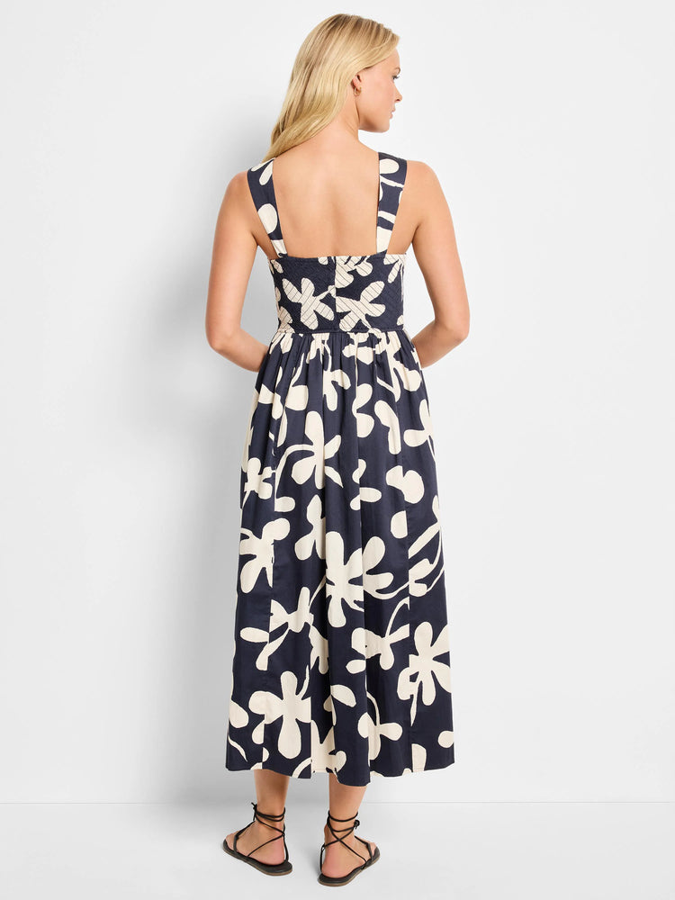 Navy midi dress with off-white stylized floral print.  Square neckline, sleeveless.  Back view.