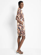 Terracotta, navy, and blush-toned leaf print knee-length shirt dress with short sleeves and pockets.