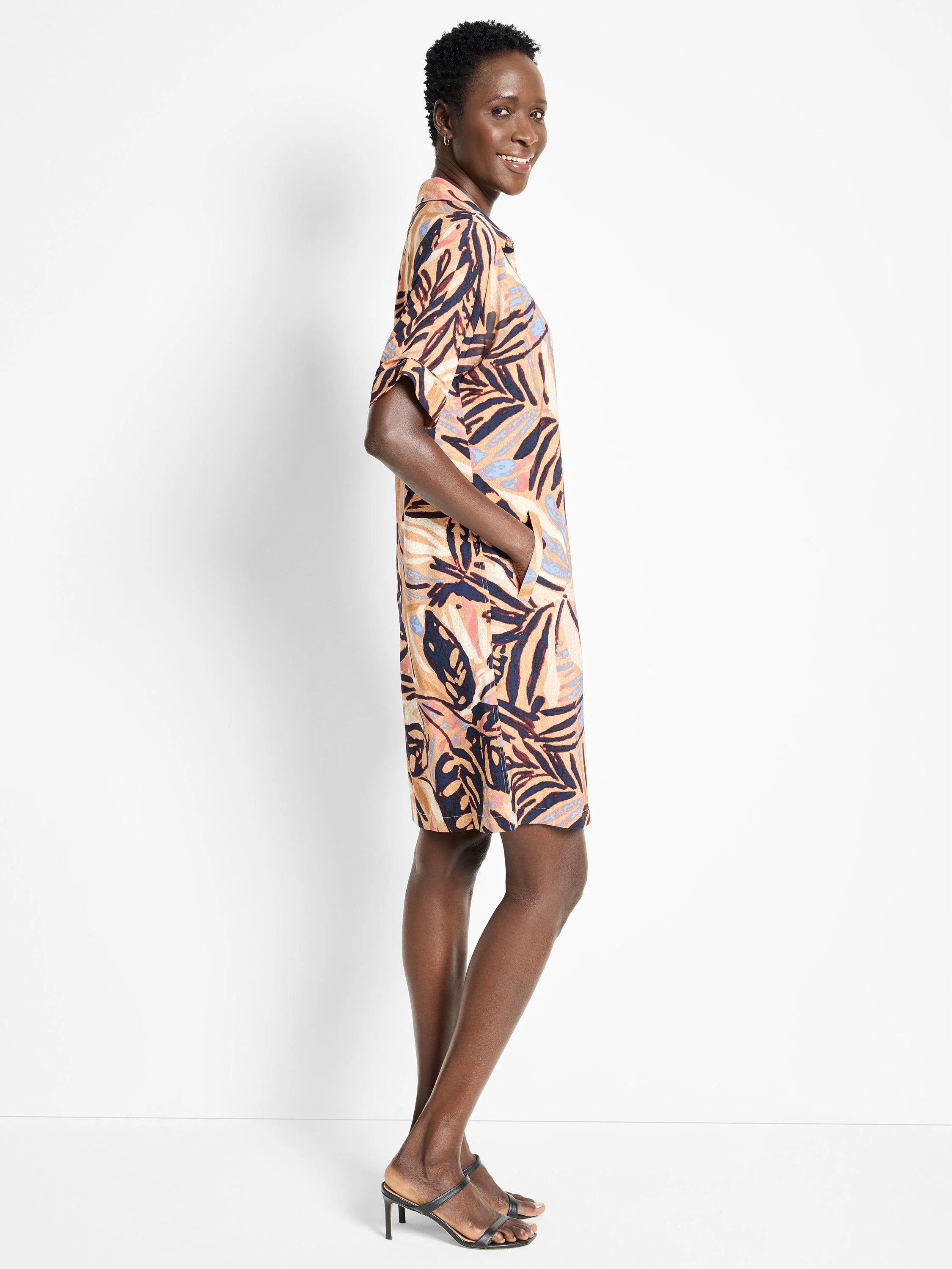 Terracotta, navy, and blush-toned leaf print knee-length shirt dress with short sleeves and pockets.