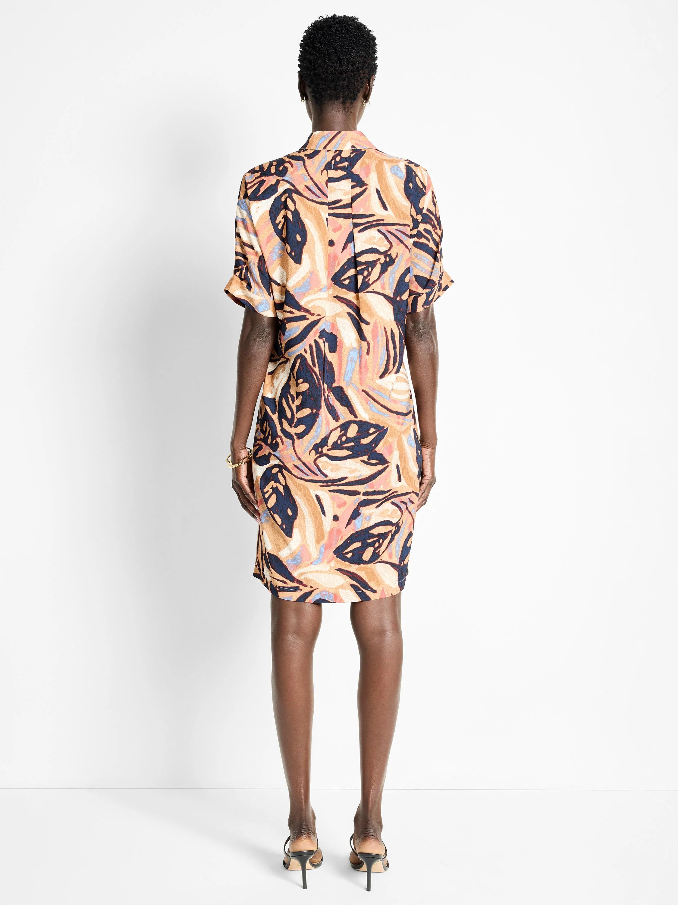 Terracotta dress with short sleeves, abstract leaf print in navy, blush pink, and beige.  Back view.