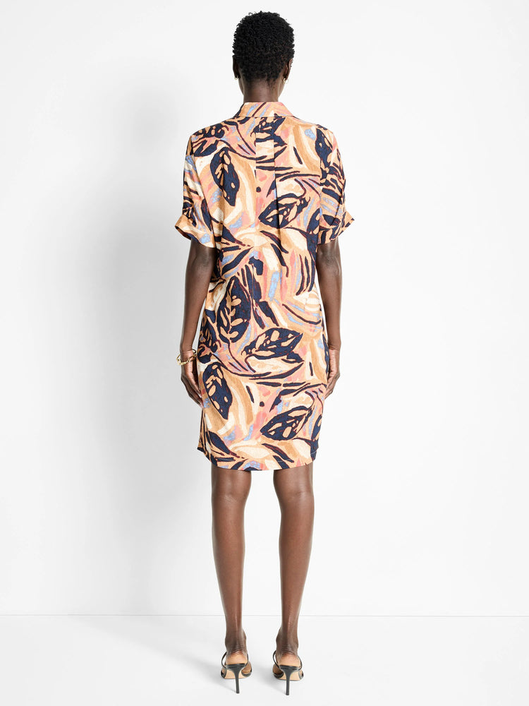 Terracotta dress with short sleeves, abstract leaf print in navy, blush pink, and beige.  Back view.