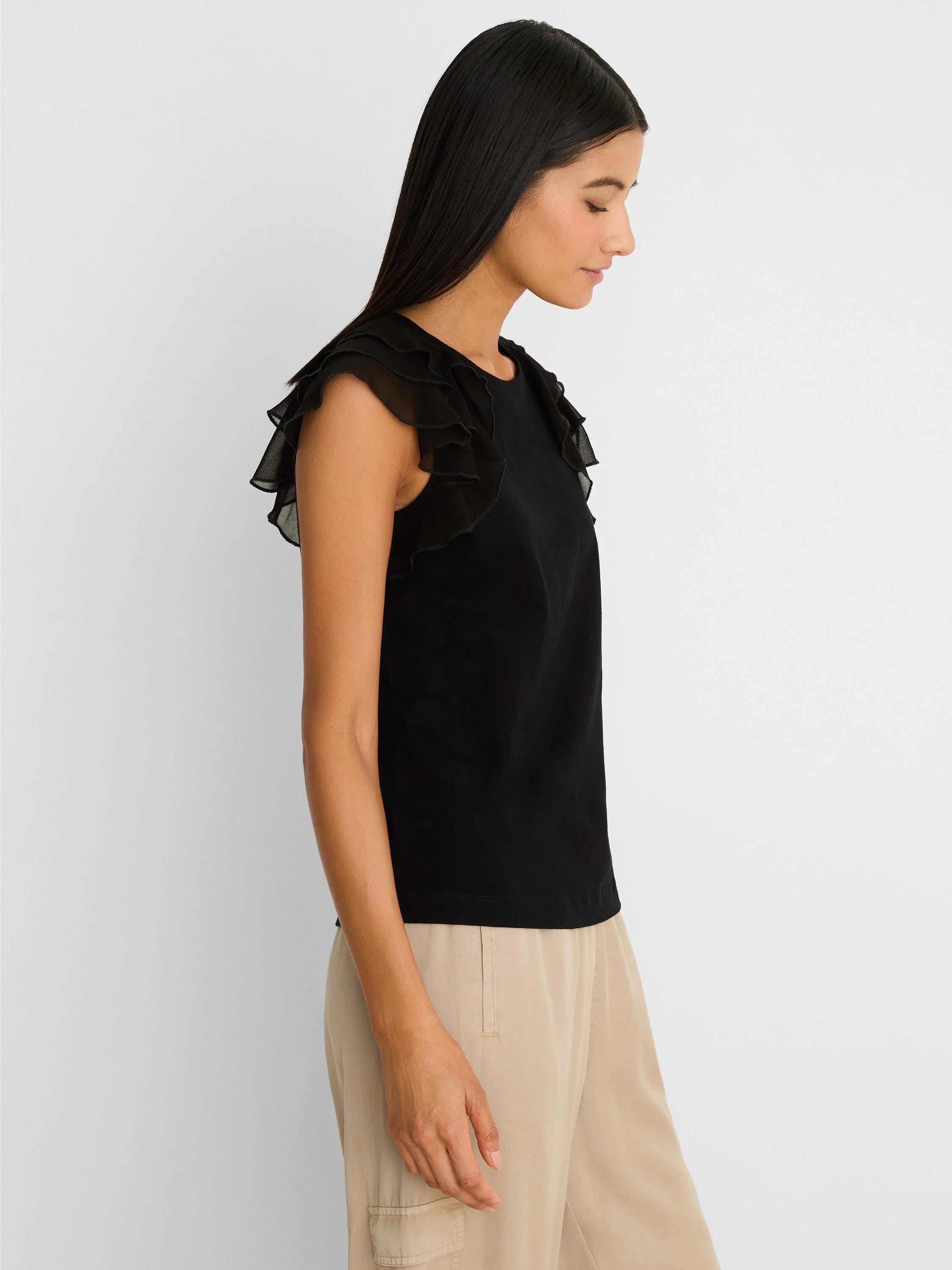 Black top with a round neckline and tiered, sheer ruffled cap sleeves.