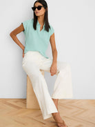 Mint green crinkle top with cap sleeves, a collared V-neck, and relaxed fit.