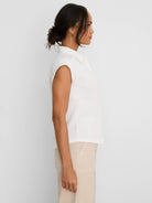 White crinkle-textured top with a collared neck and cap sleeves.