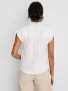 Off-white crinkle top with a collar, cap sleeves, and gathered back.