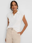 Cream crinkle top with a collared V-neck and short cap sleeves.