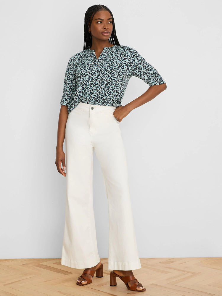 Short-sleeved teal top with a dark blue swirling vine pattern and a notched V-neck.