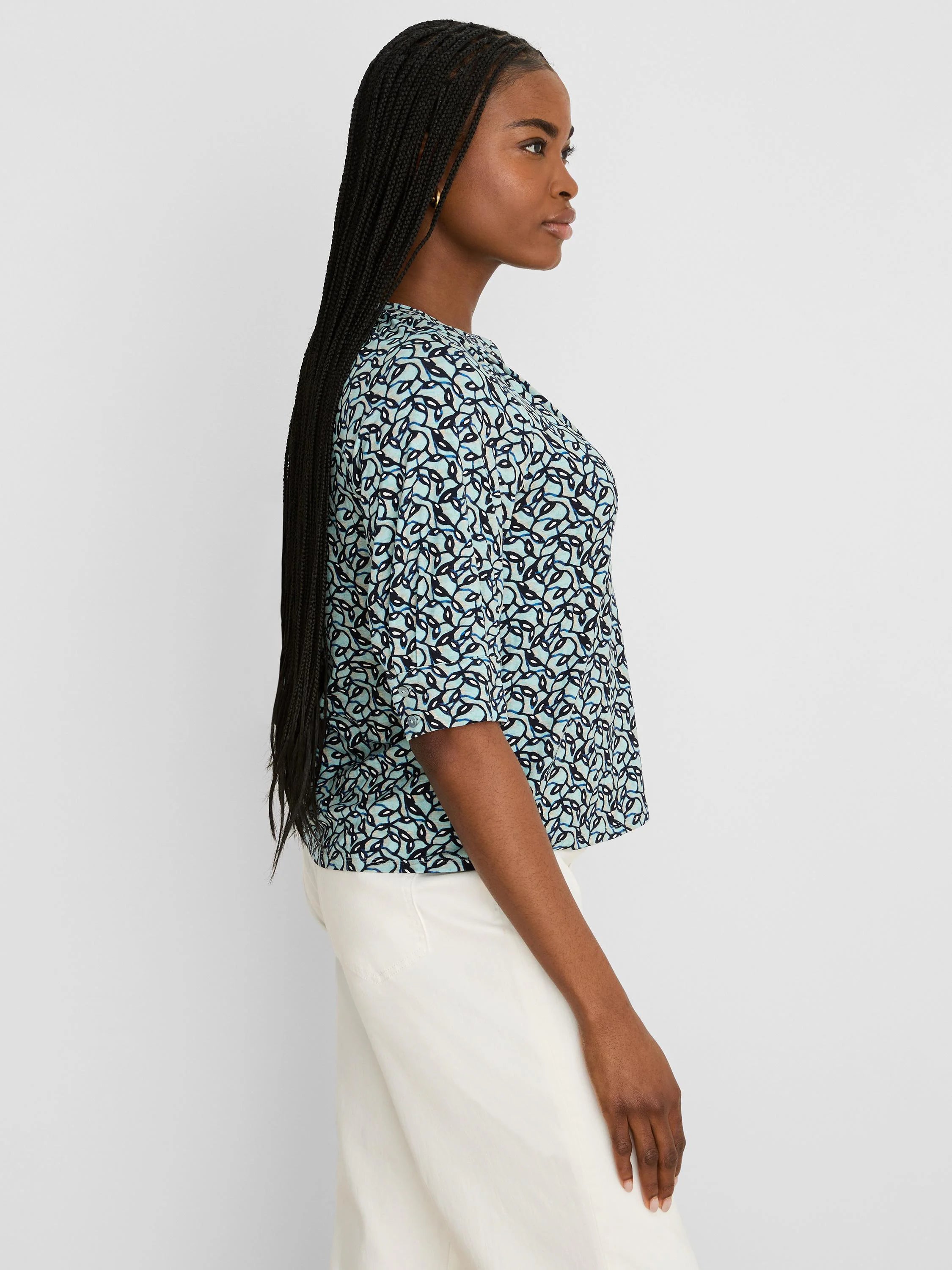 Teal and navy abstract vine pattern top with elbow-length sleeves and rolled cuffs.