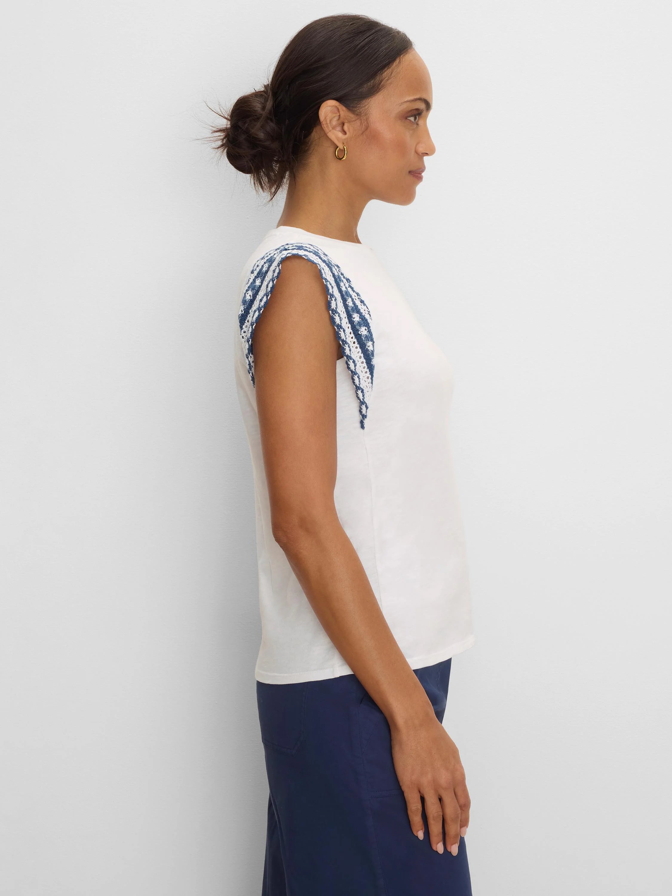 Cream cotton slub top with blue and white patterned knit trim on the shoulders.