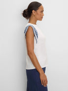 Cream cotton slub top with blue and white patterned knit trim on the shoulders.