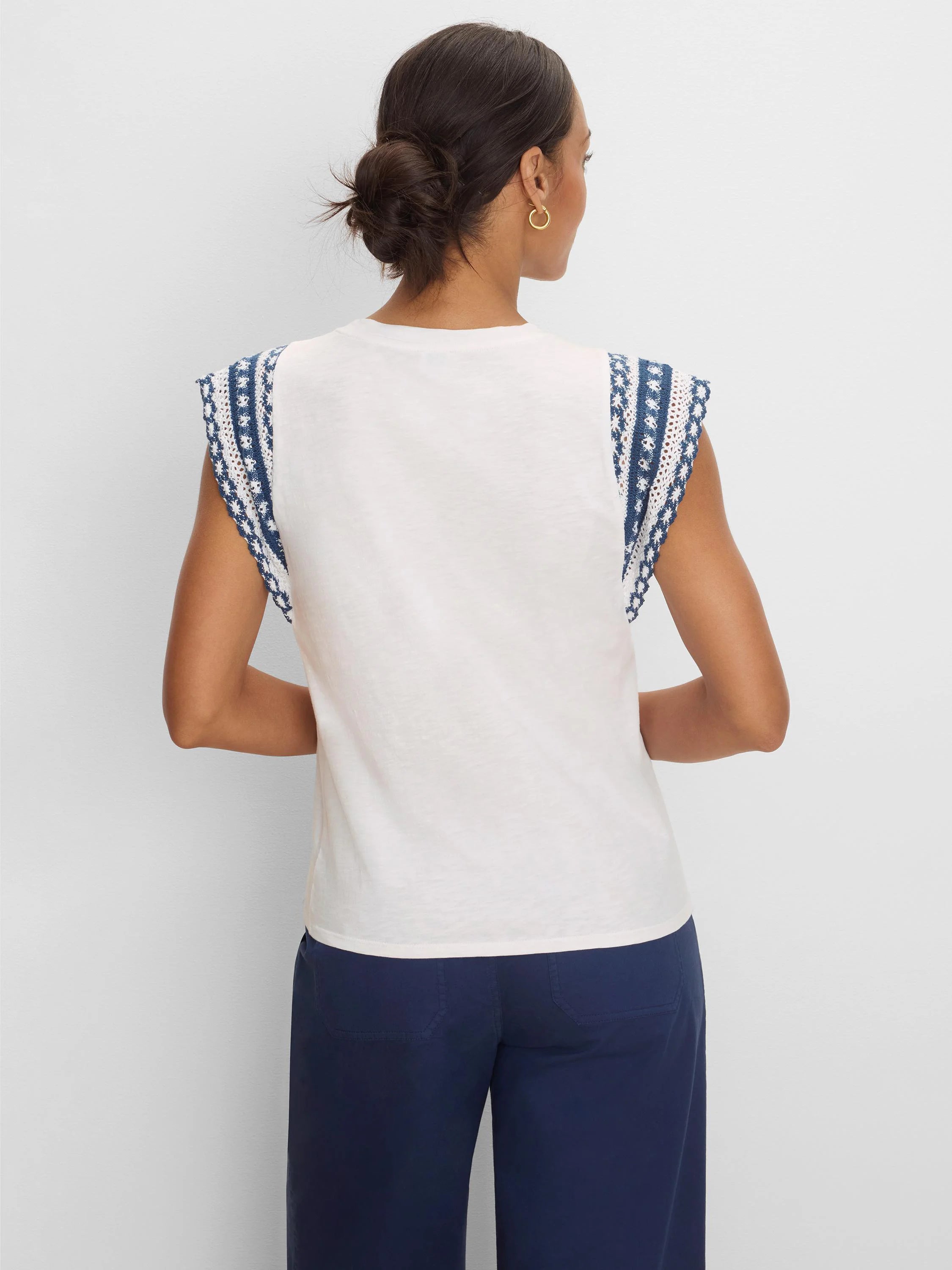 Off-white cotton slub top, back view. Cap sleeves have navy & white patterned knit trim.